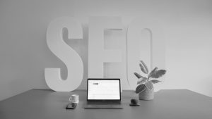 Laptop mit SEO Schriftzug im Hintergrund