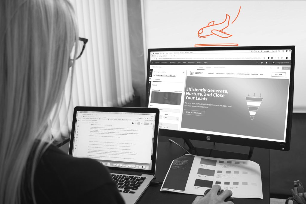Frau sitzt vor zwei Laptops und erstellt eine Landingpage