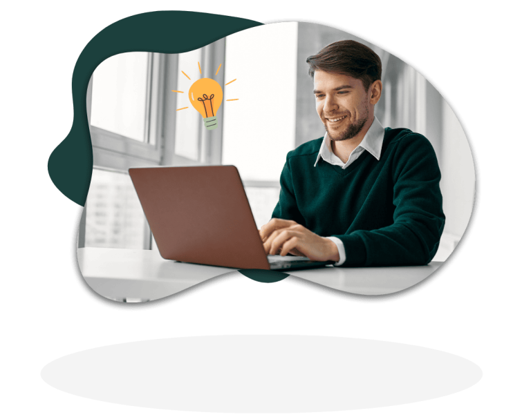 Mann sitzt an Schreibtisch und schaut auf Laptop